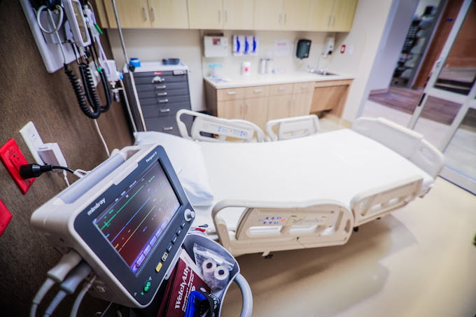 Patient treatment room with a bed and monitor